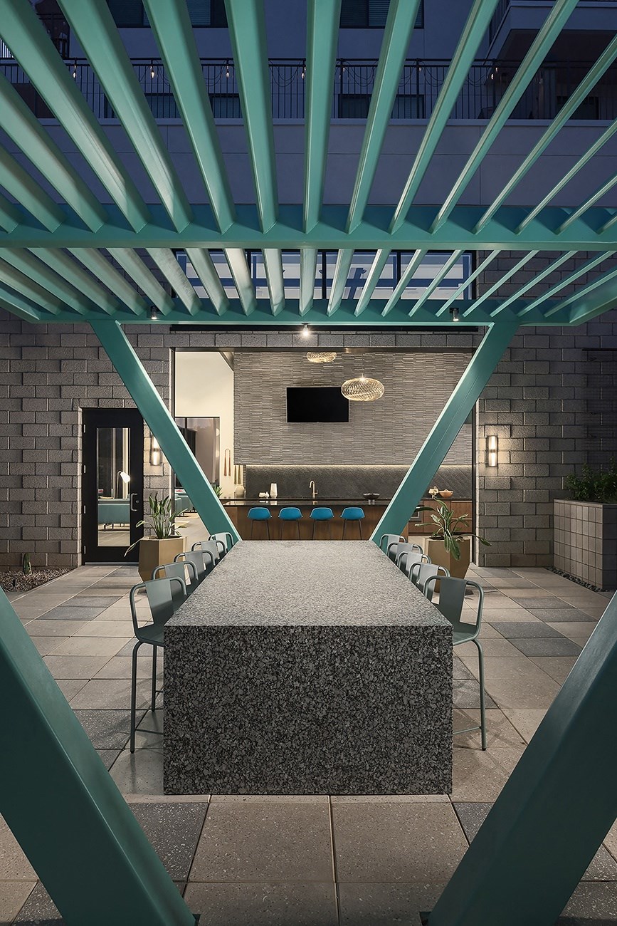 a large table with chairs under a blue structure