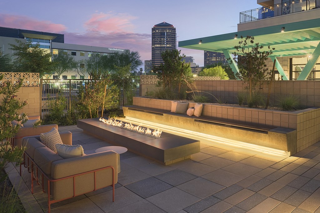 a rendering of a rooftop patio with a fire pit and furniture