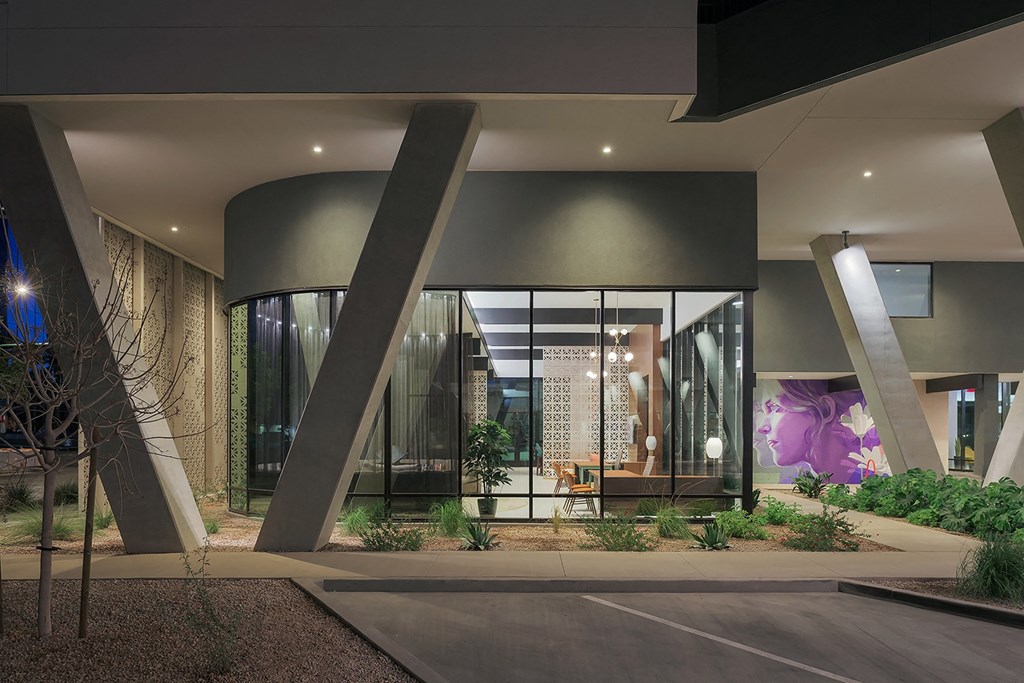 the lobby of a building with large glass windows and a courtyard