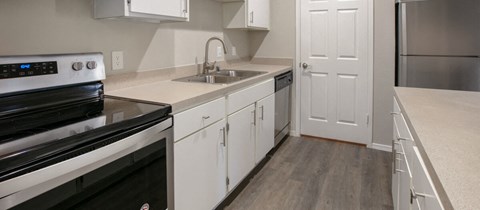 a kitchen with white cabinets and stainless steel appliances