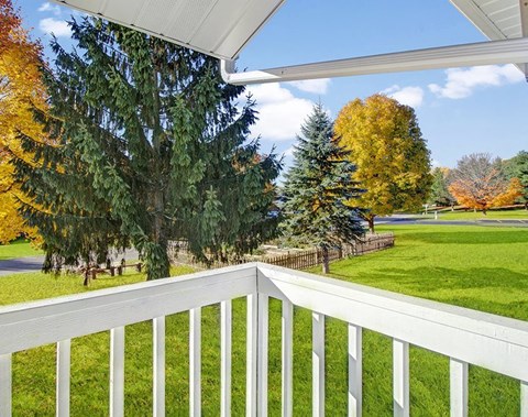 Private apartment balcony with outdoor views at Greenfield Apartment Homes in Grand Rapids, MI