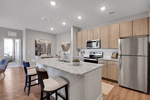 A kitchen with a white counter top and stainless steel appliances.