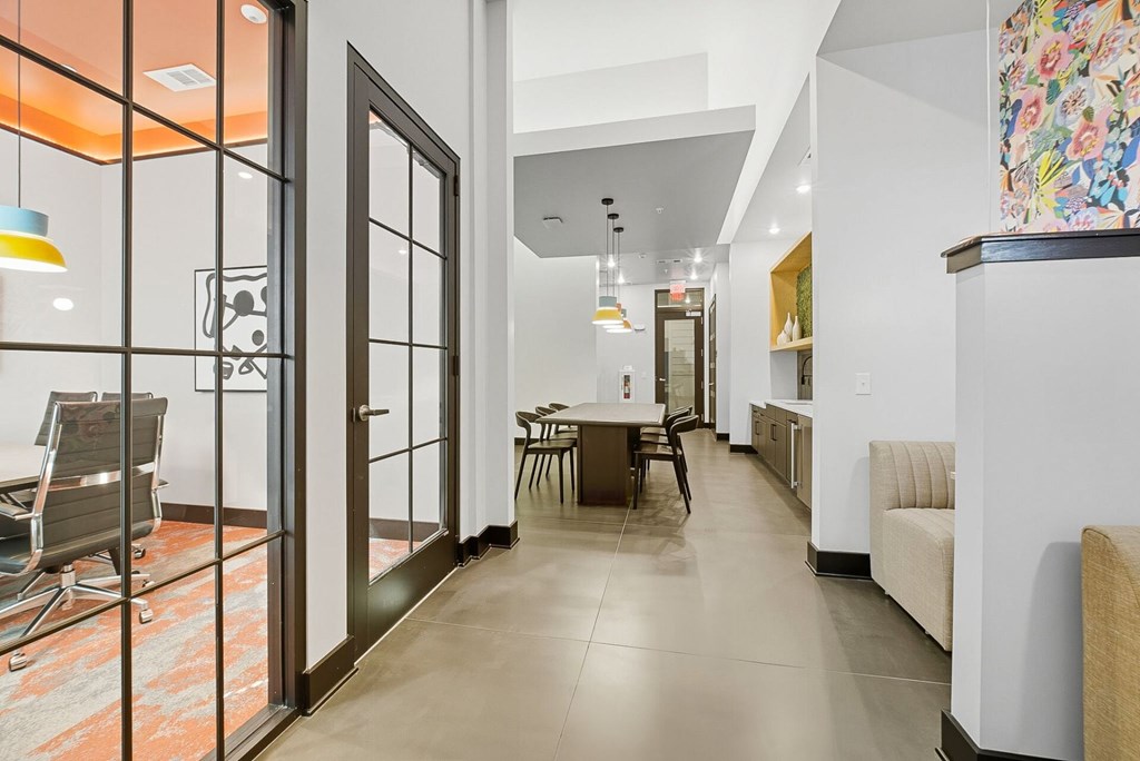 A modern living room with a glass door and a dining table.