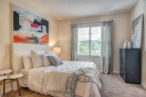 a bedroom with a bed and a dresser and a window