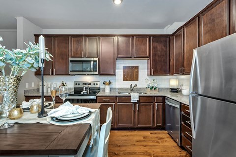 a kitchen with wooden cabinets and stainless steel appliances and a table