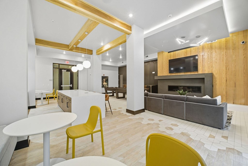 A modern living room with a yellow chair and a fireplace.