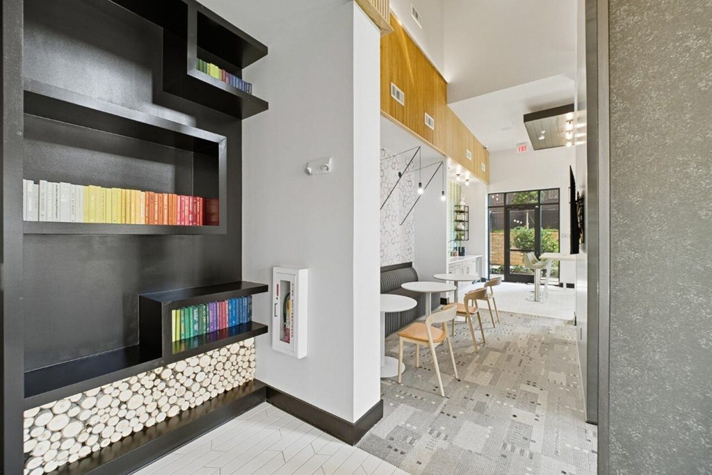 A room with a bookshelf and a table with chairs.