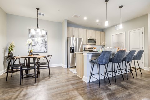 an open kitchen and dining area with a dining table and chairs