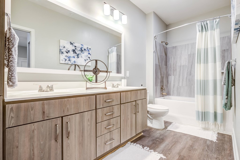 a bathroom with a large mirror and a toilet next to a bathtub
