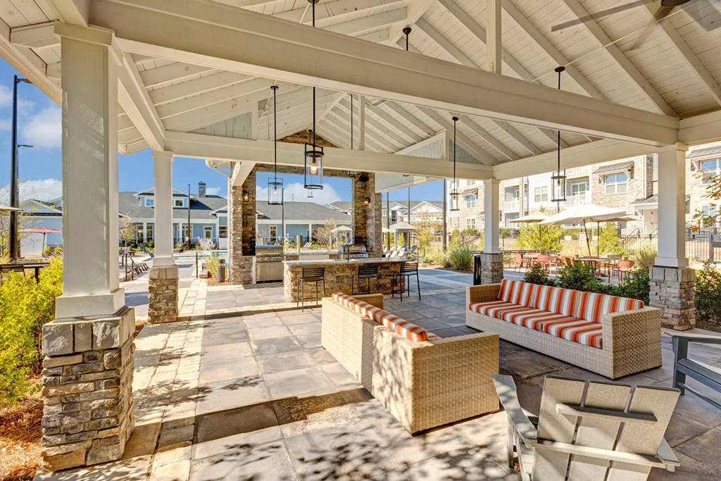 a covered patio with furniture and a table and chairs