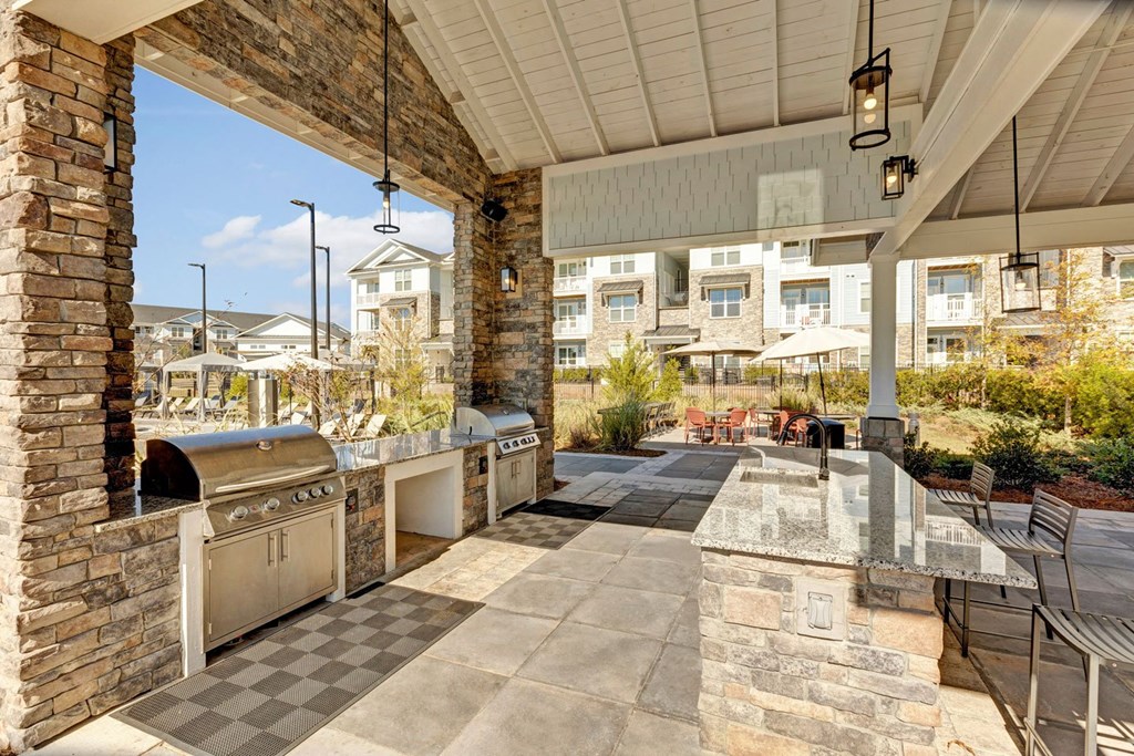 the outdoor kitchen has stainless steel appliances and a grill