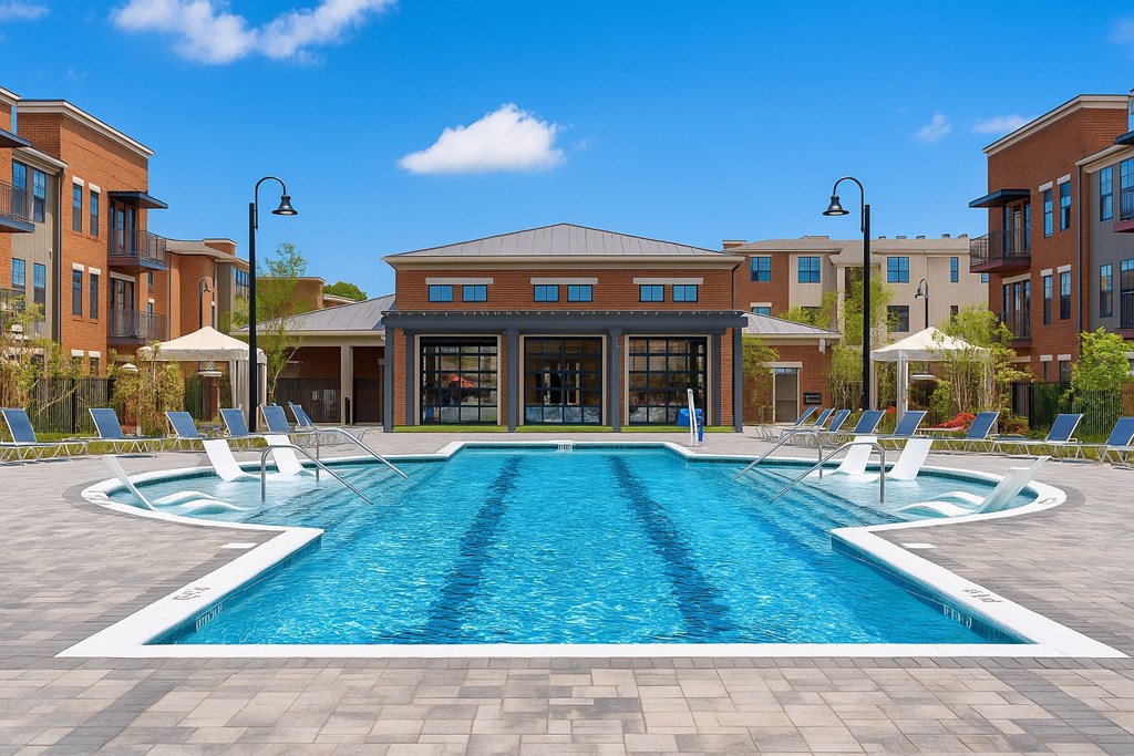 A large swimming pool in front of a building with a glass facade.