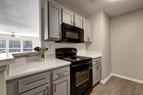 a kitchen with white cabinets and a black stove top oven