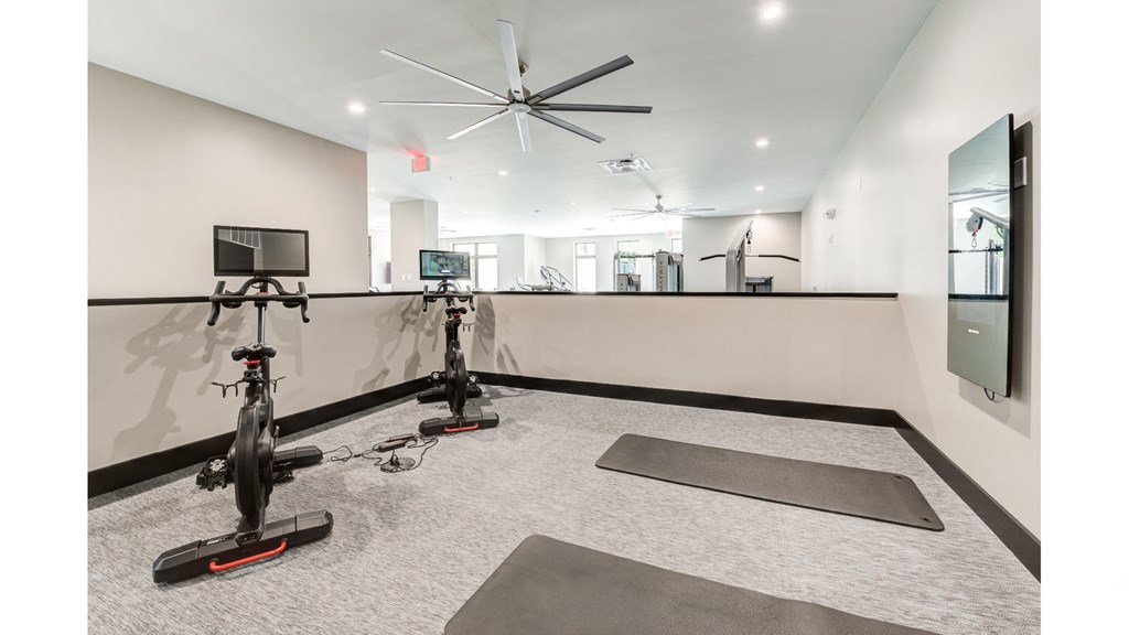 A room with exercise bikes and yoga mats.