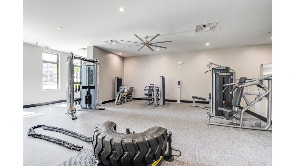 A gym with a variety of equipment including a tire flipping machine.