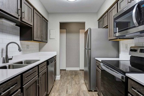 a kitchen with dark cabinets and white countertops