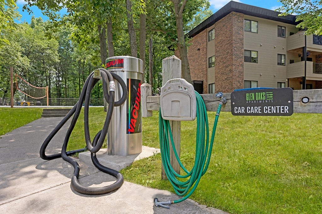 a hoses stand next to a car care center sign