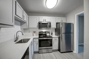 a kitchen with stainless steel appliances and white cabinets