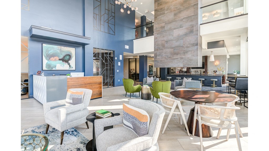 A modern living room with a blue accent wall and a variety of seating options.
