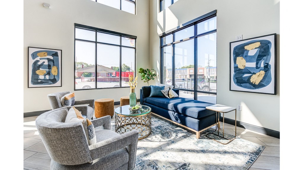 A living room with a blue sofa and two framed artworks on the wall.