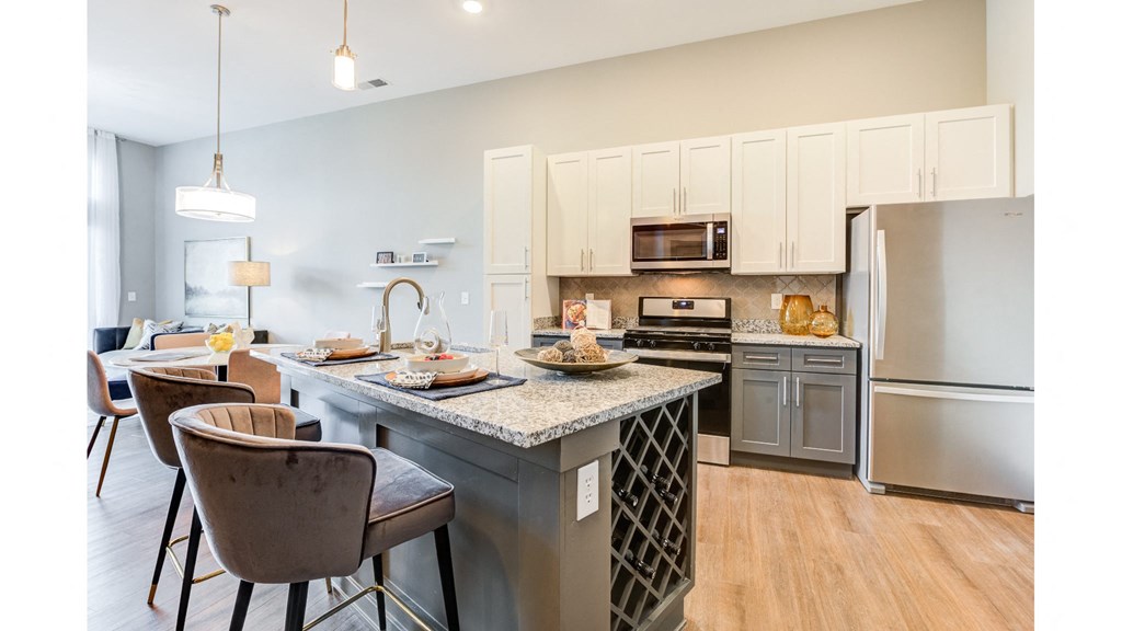 A kitchen with a table and chairs in front of it.