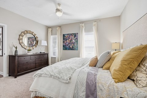 A bedroom with a large bed and a dresser with a mirror.