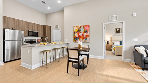 Open apartment kitchen and dining area with stainless steel appliances and breakfast bar at Argento at Sugarloaf.