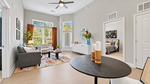 Apartment living and dining area with a round dining table, sofa and bedroom doorway at Argento at Sugarloaf.