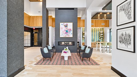 Four lounge chairs and a coffee table arranged around a clubhouse fireplace at Argento at Sugarloaf.