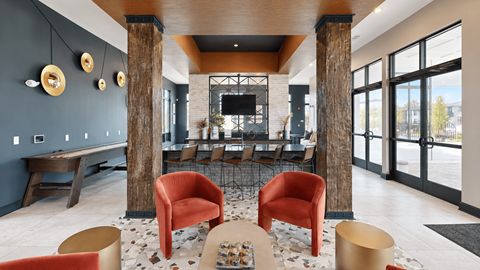 Clubhouse bar seating, television, and shuffleboard table at Argento at the Bridges in McDonough, GA.