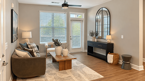 A living room with a brown couch, a coffee table, and a large mirror.