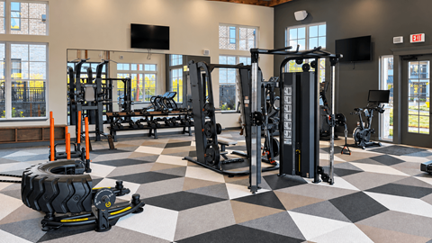 A gym with a variety of equipment including weights and cardio machines.