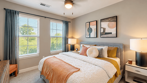 A bedroom with a large bed and a view of the outdoors through the window.