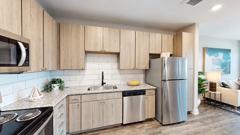 A modern kitchen with wooden cabinets and stainless steel appliances.