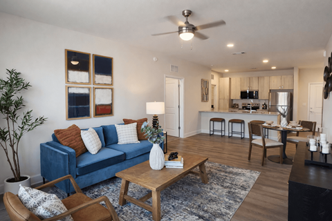 A living room with a blue couch and a wooden coffee table.