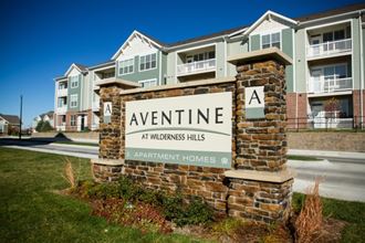 an apartment building with a sign for avenue at wilderness hills