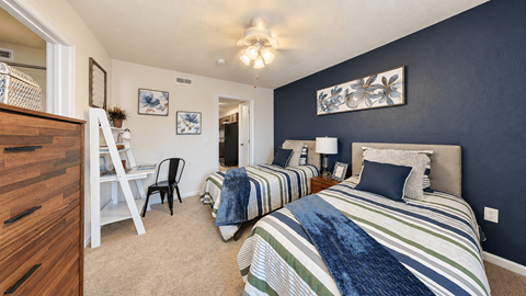 A bedroom with two beds and a chair.