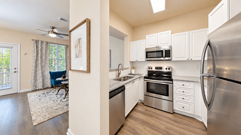 Apartment kitchen with white cabinets, stainless steel appliances, and a tile backsplash at Elevation 3505 in Atlanta, GA.