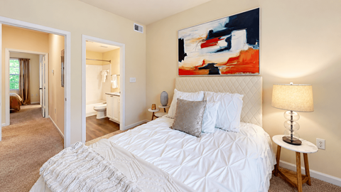 Bedroom with white bedding and an open doorway to the adjoining bathroom at Elevation 3505 in Atlanta, GA.