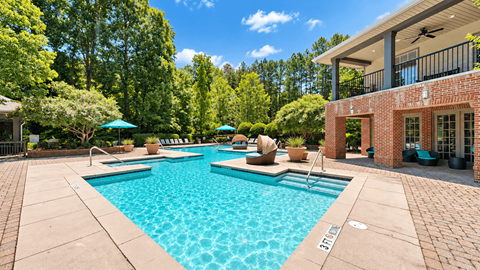 Swimming pool with shaded daybeds and a covered clubhouse patio at Elevation 3505 Apartments & Townhomes in Atlanta, GA.