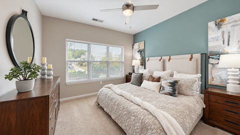 Furnished bedroom with a ceiling fan and large window at Enclave at Bailes Ridge in Indian Land, SC.