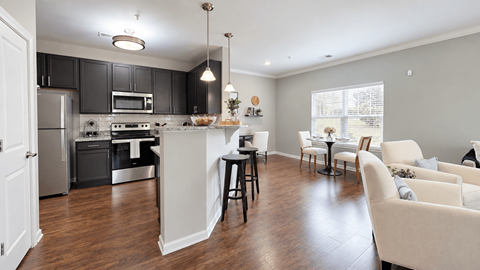 Open kitchen and living area with breakfast bar seating at Enclave at Bailes Ridge in Indian Land, SC.