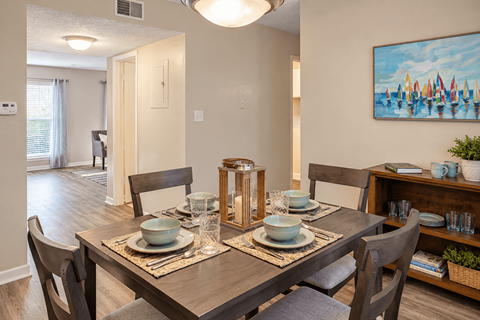 Dining area with wood-style flooring and space for a four-person table at Madison Park Apartments & Townhomes in Birmingham, AL.