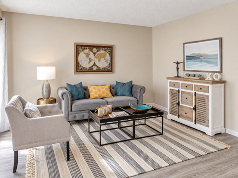 Apartment living room with wood-style flooring and spacious seating area at Madison Park Apartments & Townhomes in Birmingham, AL.