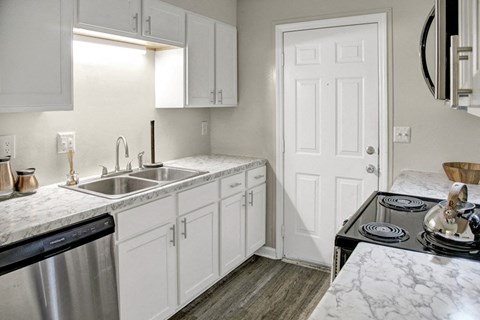 a kitchen with white cabinets and a sink and a stove