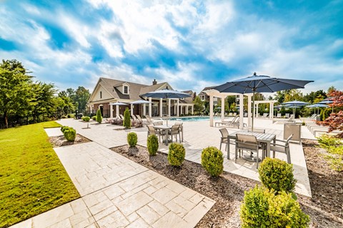 Resort-style outdoor swimming pool and furnished pool deck at The Moderne at Providence Apartments