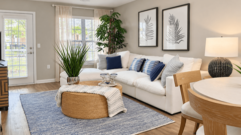 Furnished apartment living room with white sectional, woven coffee table and patio door at Seaside Grove Apartments in Myrtle Beach, SC.