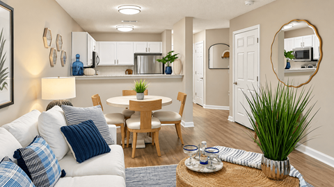 Open apartment living and dining area facing a kitchen with a breakfast bar at Seaside Grove Apartments in Myrtle Beach, SC.