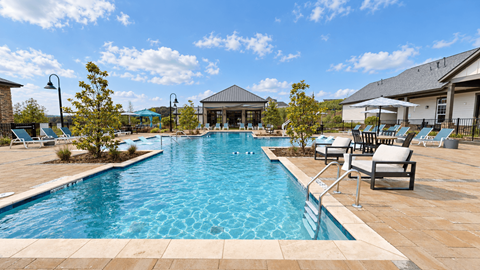 Swimming pool with lounge chairs and poolside clubhouse at The View on Canton in Cartersville, GA.