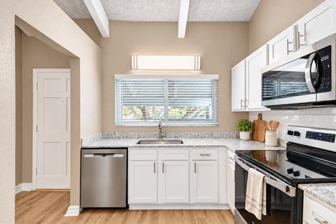 Kitchen with white cabinetry and a window at Waterchase Apartments in Largo, FL.